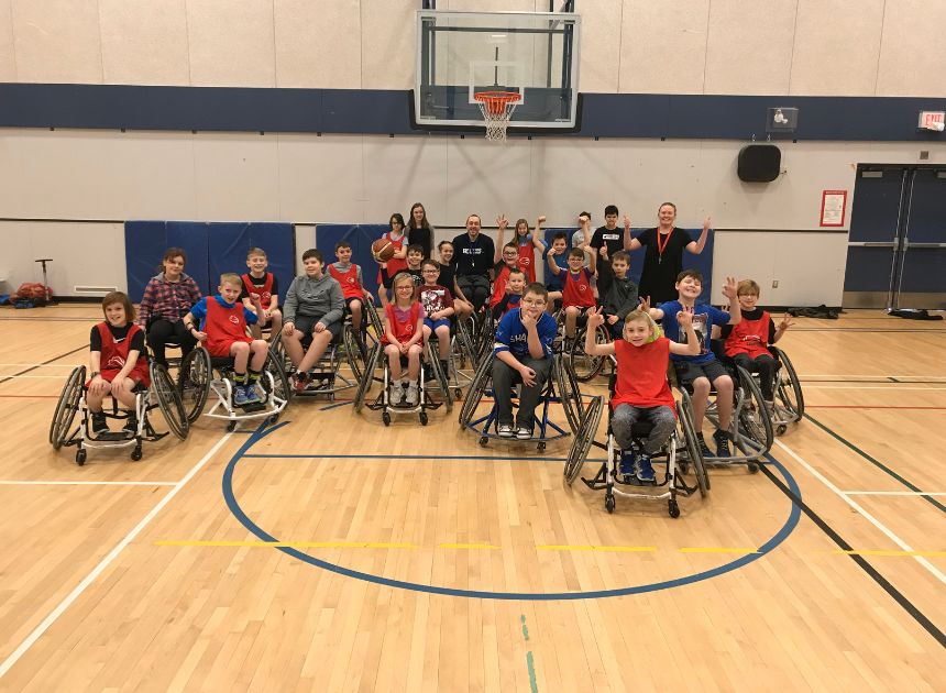 Group of young wheelchair athletes in school gymnasium