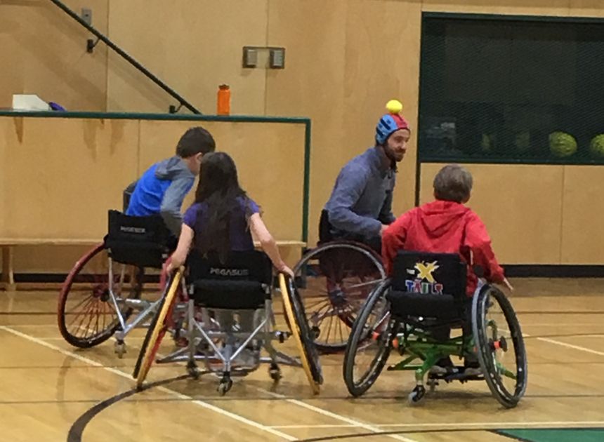 Four people participating in wheelchair games indoors